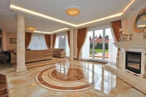 Luxurious, spacious living area with elegant marble flooring and large windows photo
