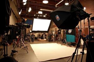 Studio set-up for filming. Several cameras, lights, and equipment are positioned for a production photo