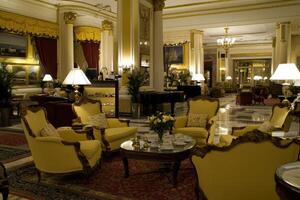 Luxurious hotel lobby with plush seating, ornate details, and warm lighting photo