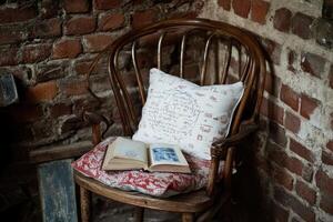 Cozy corner with antique chair, book, and pillow photo