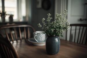 A simple bouquet of wildflowers in a grey vase on a wooden table photo