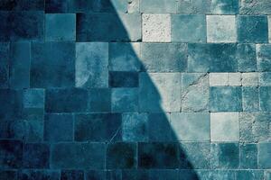 Textured teal-toned tile wall with shadow photo