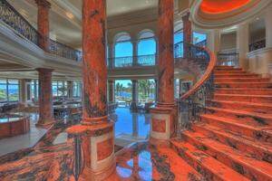 Luxurious, red marble staircase in a grand, opulent home with ocean views photo