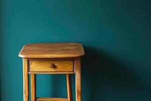 Simple wooden side table against teal wall photo