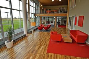 Modern open-plan lobby with large windows, comfortable seating, and natural light photo