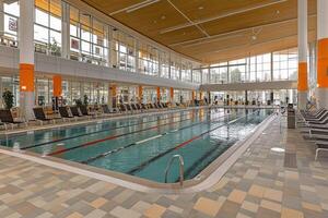 Spacious indoor pool with lounge seating photo