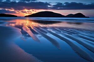 Sunrise over tranquil beach, sand patterns reflected in water photo