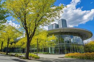 Modern building surrounded by lush greenery, under a partly cloudy sky photo