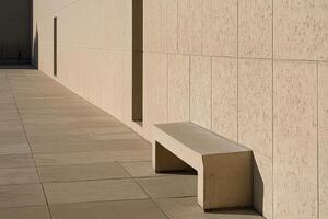 Simple bench beside a light beige wall photo