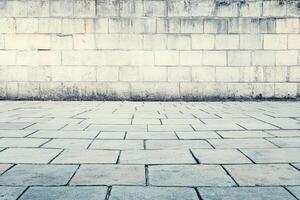 Urban paved area against a weathered stone wall photo