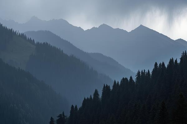 Misty mountain range, layered with forests