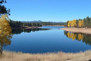 Serene autumn lake reflecting mountains photo