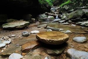 Tranquil mountain stream with smooth rock photo