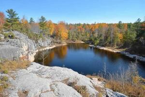 Autumnal ravine with a tranquil lake nestled within rocky outcrops photo