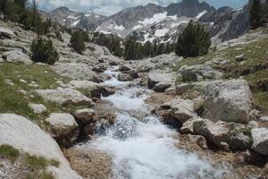 Mountain Stream Cascades Through Rocky Terrain photo