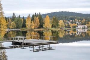 Autumnal lake scene with wooden dock photo