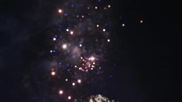 blurred beautiful colorful festive fireworks display at the celebration of pyrotechnic show on background of the night sky with color bokeh video