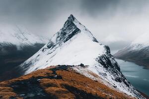 Snowy mountain peak, dramatic clouds, and tranquil lake photo