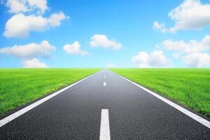 Empty road stretches into a bright blue sky photo