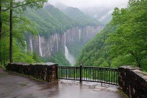 Misty mountain view of cascading waterfalls. Lush green valley and trees frame the falls photo