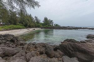Tranquil cove bathed in soft light. Rocky shoreline meets calm turquoise water photo