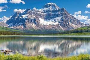 Majestic mountain reflected in a serene lake. Lush valley and snow-capped peak photo