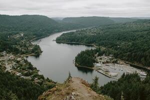 Panoramic view of a winding river valley. Dense forest surrounds a town nestled along the water photo