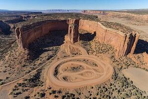 High-angle view of a winding dirt road through a desert canyon photo