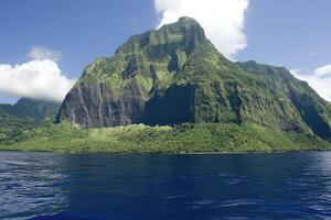 Lush island peak rising above turquoise water photo
