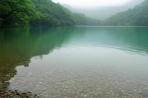 Serene mountain lake reflecting lush foliage photo
