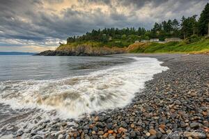 Coastal scene with waves crashing on a pebble beach photo