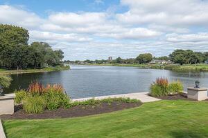 Tranquil lake vista with manicured grounds photo