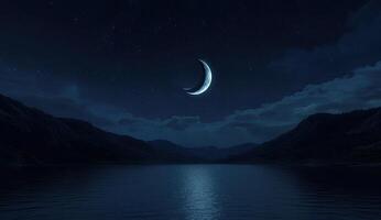 Crescent moon over a tranquil lake at night photo
