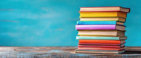 The vibrant stack of colorful books on a wooden surface. photo
