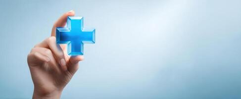 The hand holding a blue cross symbolizing health and wellness in modern healthcare. photo