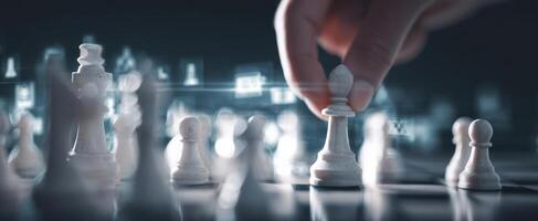 The hand moving a pawn in a strategic chess game against a digital backdrop. photo