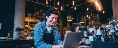 The smiling barista working on a laptop in a cozy coffee shop. photo