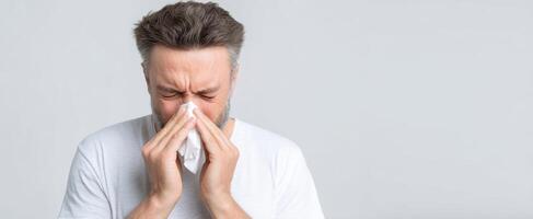 The distressed man wiping his nose with a tissue in a studio setting. photo