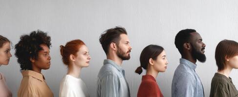 The diverse group of individuals standing side by side in profile. photo