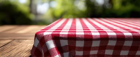 The picnic table adorned with a vibrant red and white checkered cloth. photo