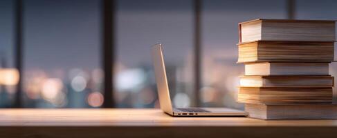 The laptop and books on a modern desk overlooking a city skyline. photo