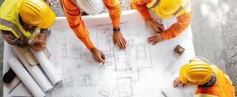 The construction team collaborating over blueprints and project plans. photo