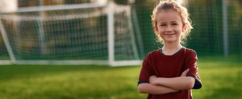 The confident young girl posing on a soccer field with a goal in the background. photo