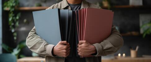 The person holding multiple folders in a stylish office environment. photo