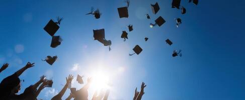 The joyous celebration of graduates tossing caps under a bright blue sky photo