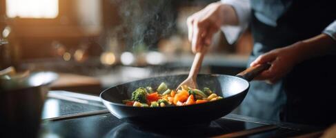 The chef stirring vibrant vegetables in a black frying pan. photo