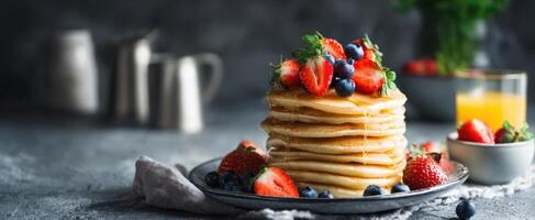 Stack of pancakes with berries and syrup on a plate photo
