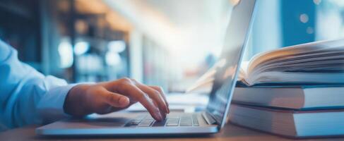 The laptop on a desk with books, capturing a moment of productivity. photo