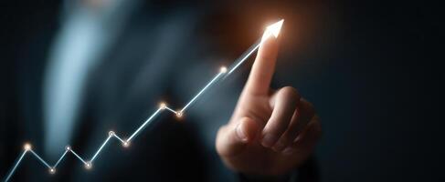 The business professional illustrating upward growth with a finger pointing at a rising chart photo