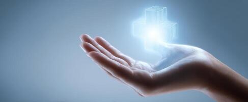 The hand presenting a glowing digital medical cross symbol for wellness. photo